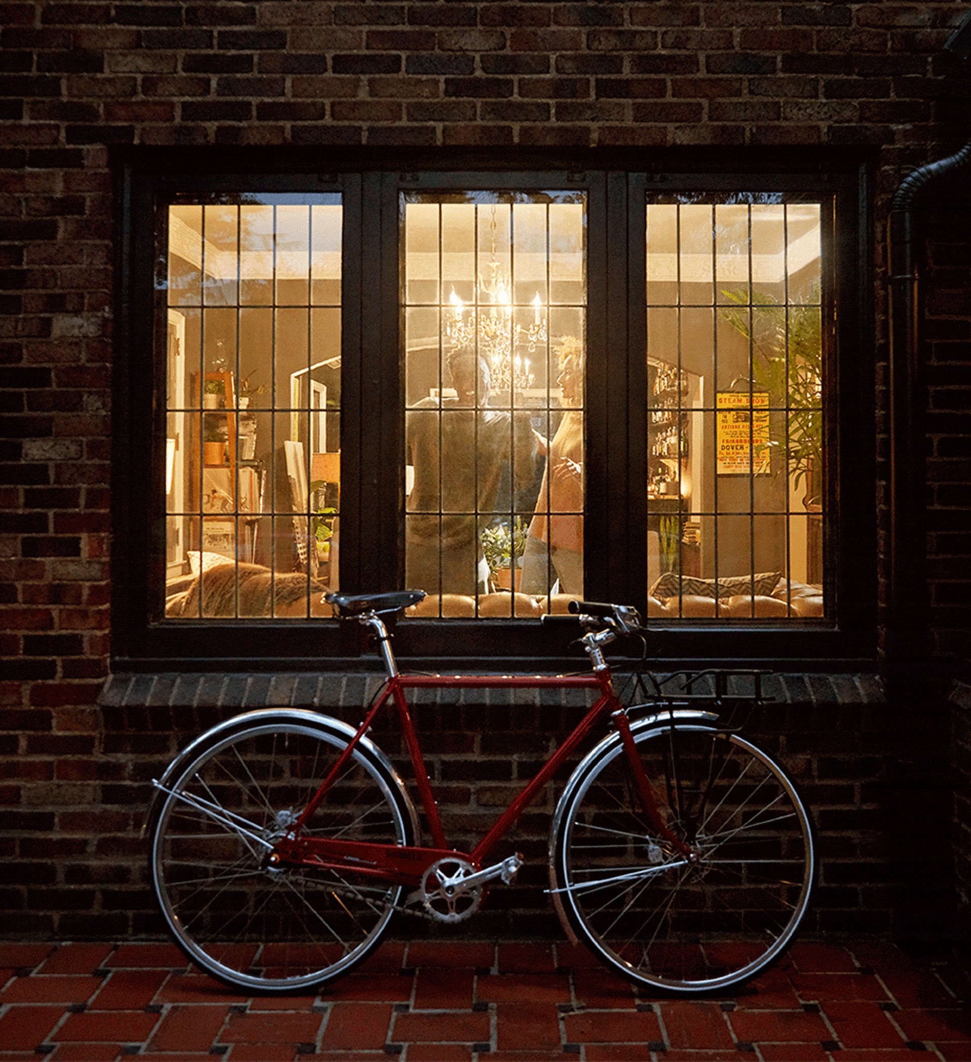 A man and woman inside their home, with a bike resting against their window